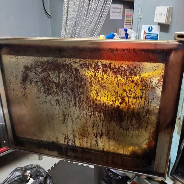 Commercial oven door covered with baked-on grease before a specialist deep clean in Tamworth.