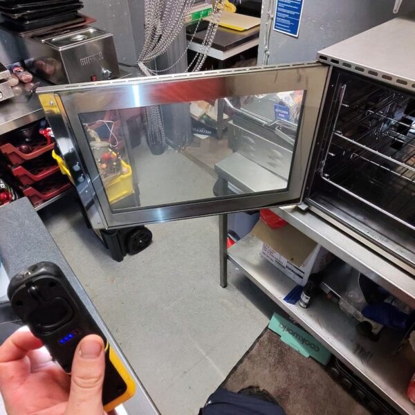 Clean Buffalo commercial oven door glass and interior following a professional kitchen deep clean.
