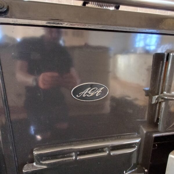 Close-up of the black AGA enamel and handles before a full detail clean in Ratcliffe Culey.