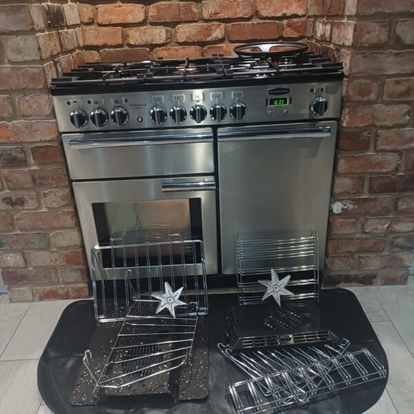 Clean stainless steel Rangemaster Professional range cooker in Hopwas with removed shelves, panels and fan covers laid out in front.